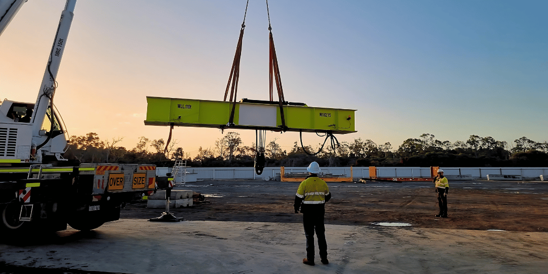 Promet team using advanced rigging techniques to safely lift rubber tyred gantry crane onto b-double truck bed for transportation